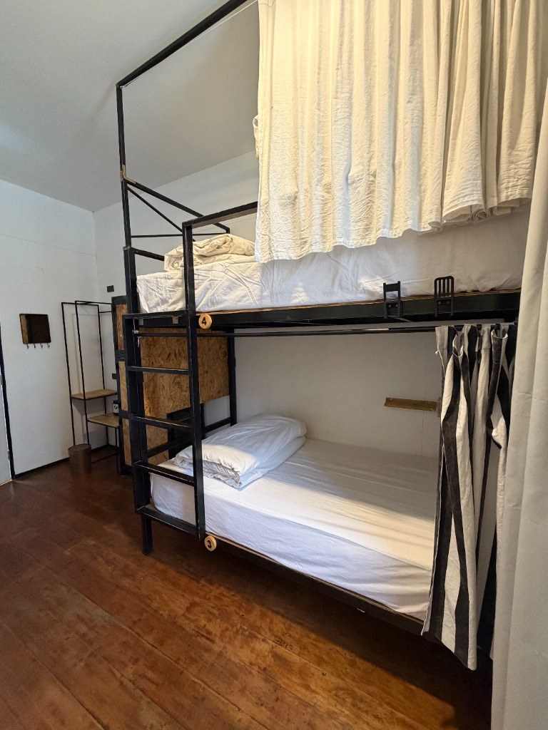 Cozy bunk bed pod with full privacy curtain and plush white bedding